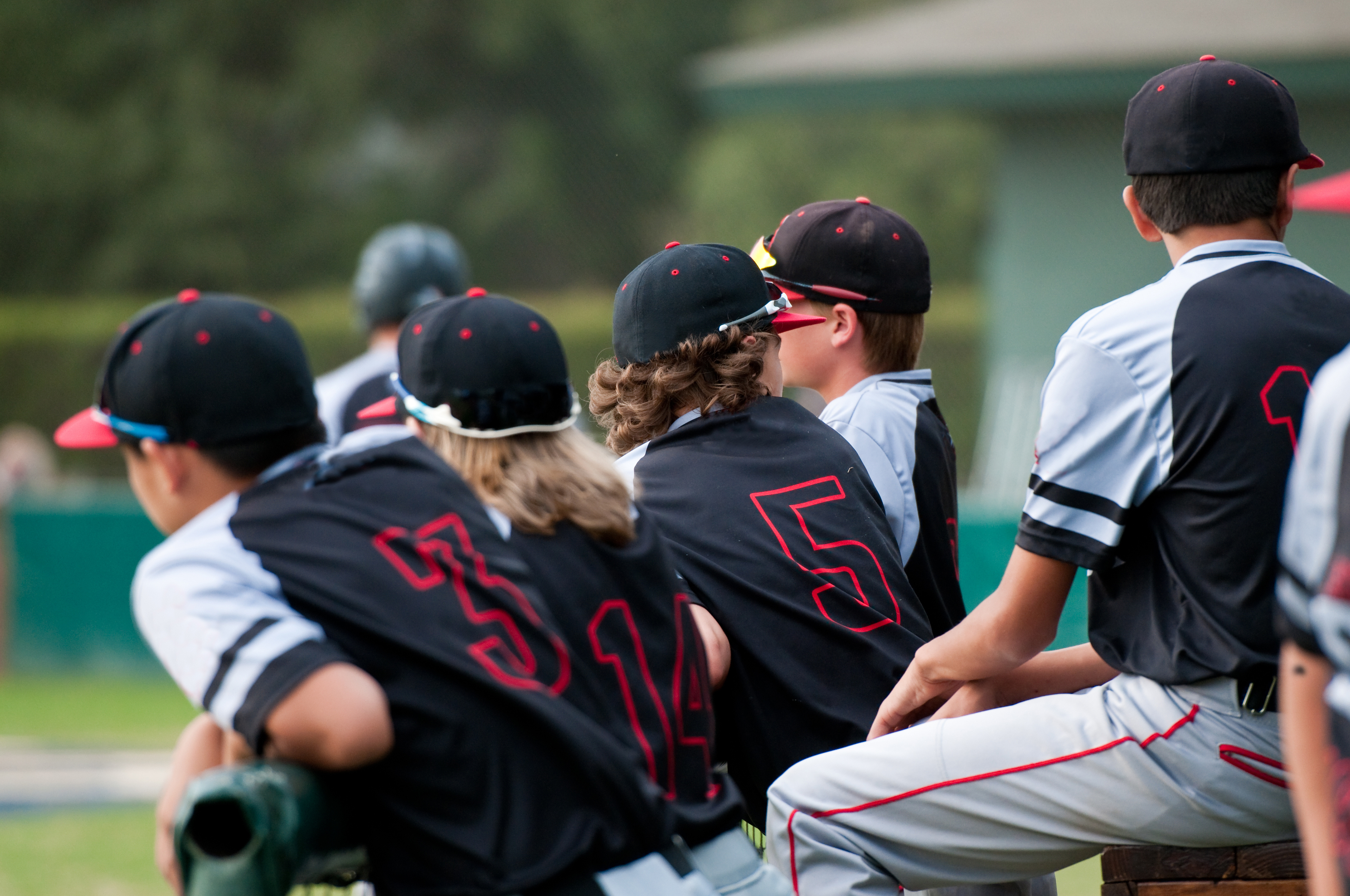 Youth players watching a pinch hitter from the dugout