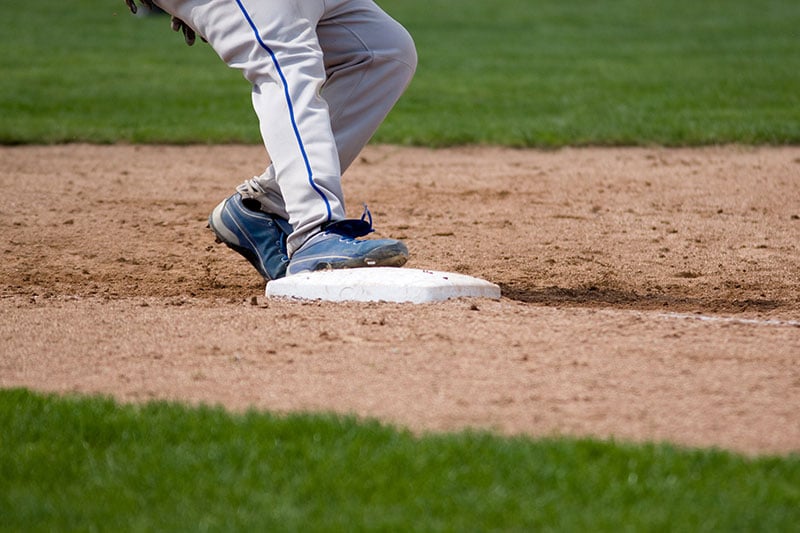 Baseball player tagging up on a base.