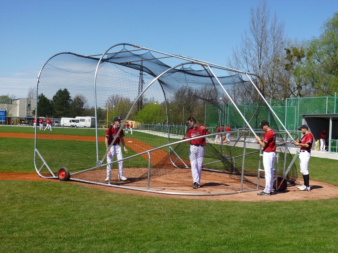 baseball players in a batting cage