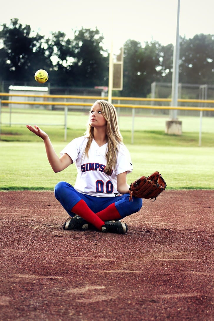 Softball girl sitting on the field